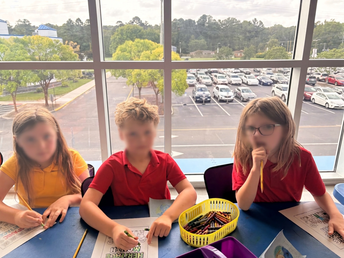 Students coloring Heritage Month pages by the window