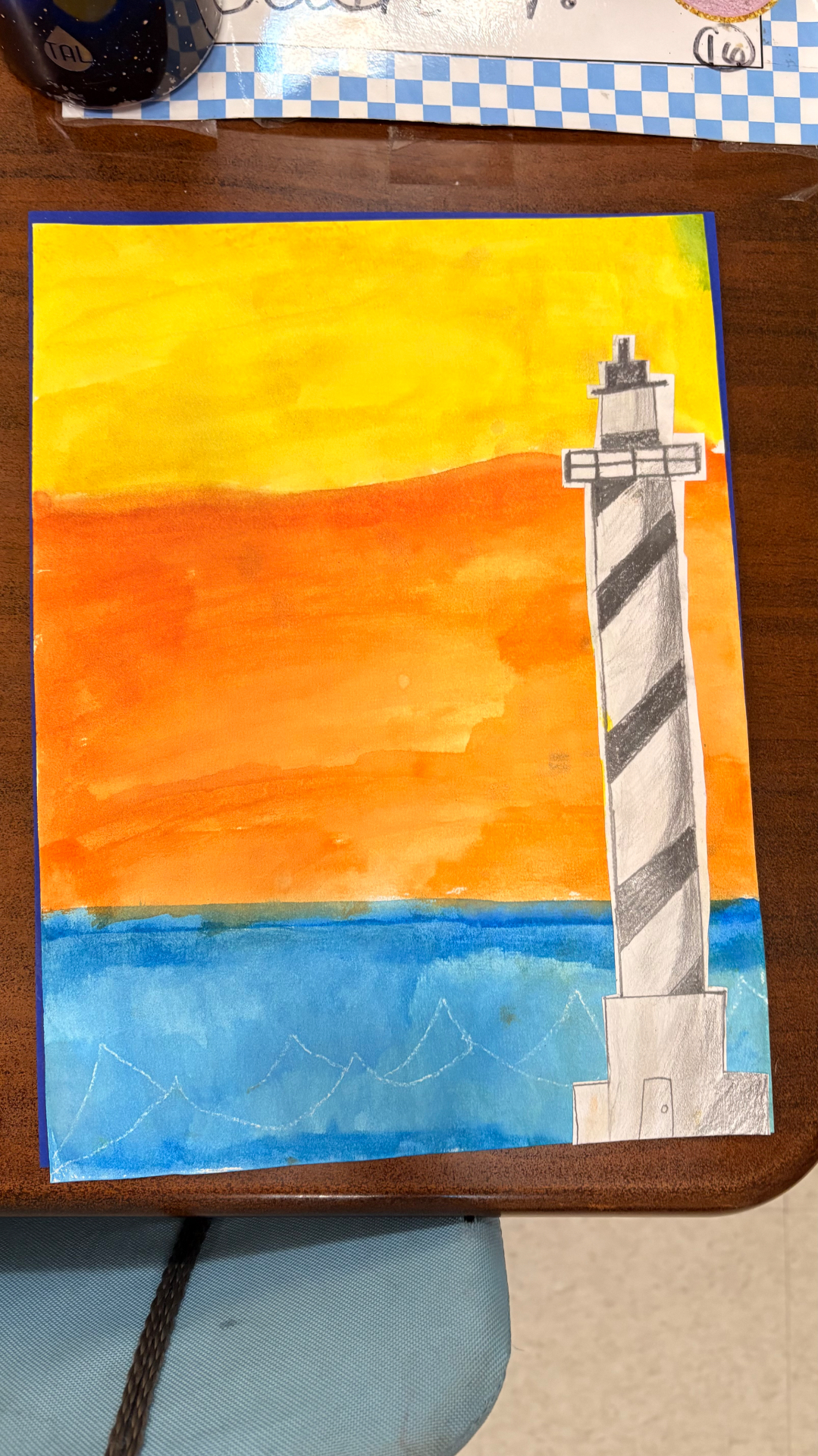 Lighthouse drawing against a bright yellow and orange sunset over blue water